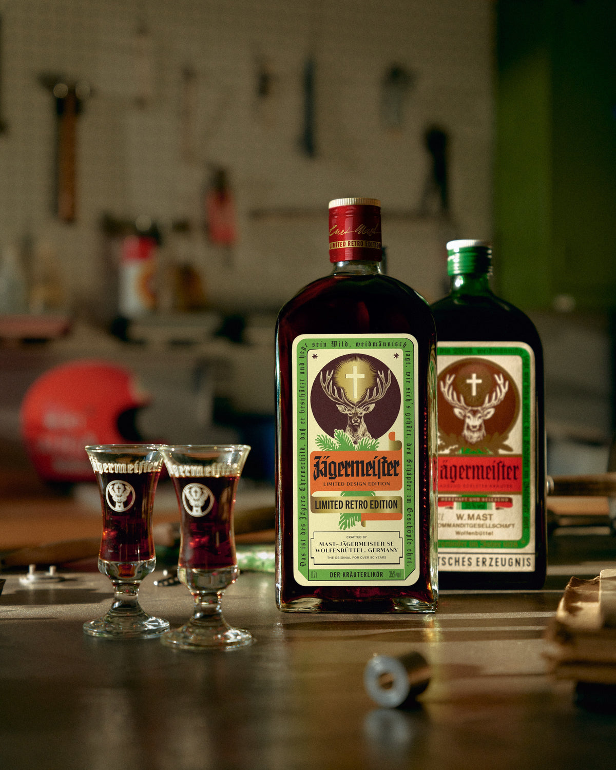 Two retro-bottle Jägermeister and retro shot glasses in a mechanics garage.