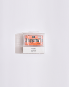 appareil photo orange dans un emballage plastique transparent sur fond blanc