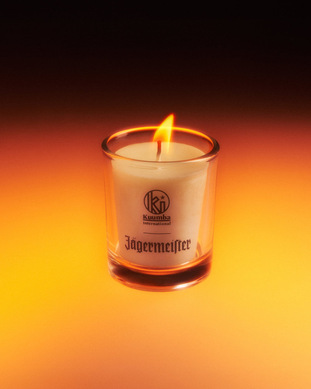 Bougie Jagermeister dans un récipient en verre sur fond sombre