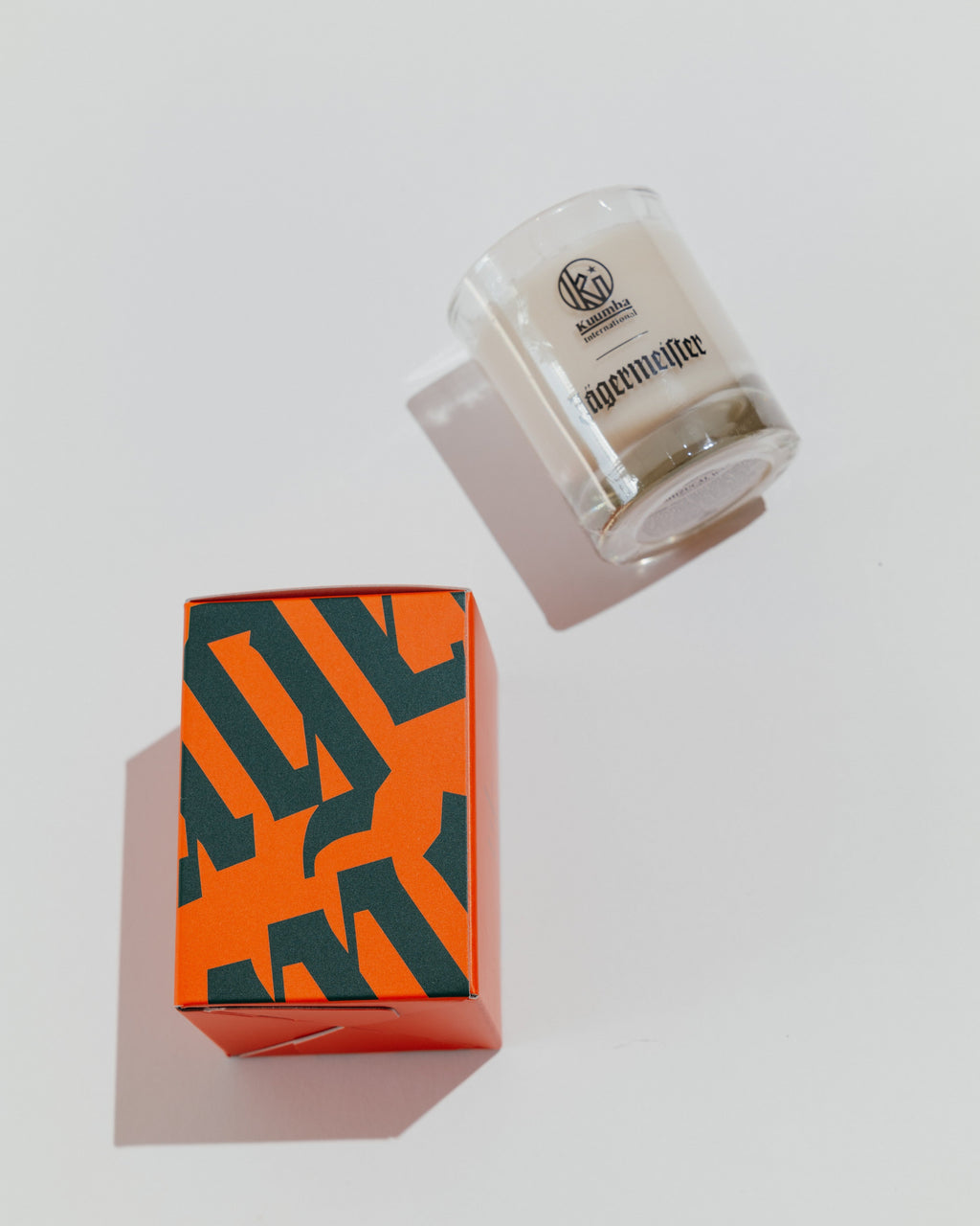 Bougie Jägermeister avec boîte décorative portant le wordmark Jägermeister en vert et orange
