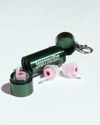 Bouchons d’oreilles dans un étui métallique vert avec un logo Jägermeister blanc dessus, sur fond blanc