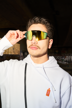 Person wearing reflective Jägermeister sunglasses and a white hoodie with a bottle logo.