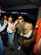 Group of people taking Jägermeister shots at a social gathering, featuring a person wearing Jägermeister Fast Glasses with mirrored lenses and an aerodynamic design.