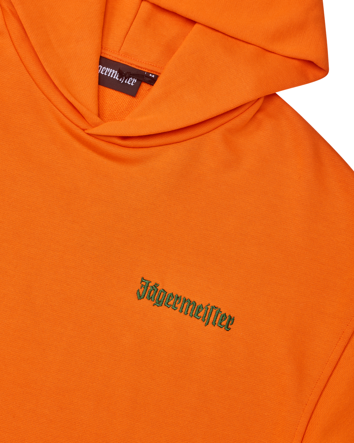 Sweat à capuche orange avec wordmark vert Jägermeister sur la poitrine.