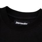 Gros plan sur le col d’un T-shirt noir Jägermeister avec une étiquette tissée du logo Jägermeister à l’intérieur de l’encolure.