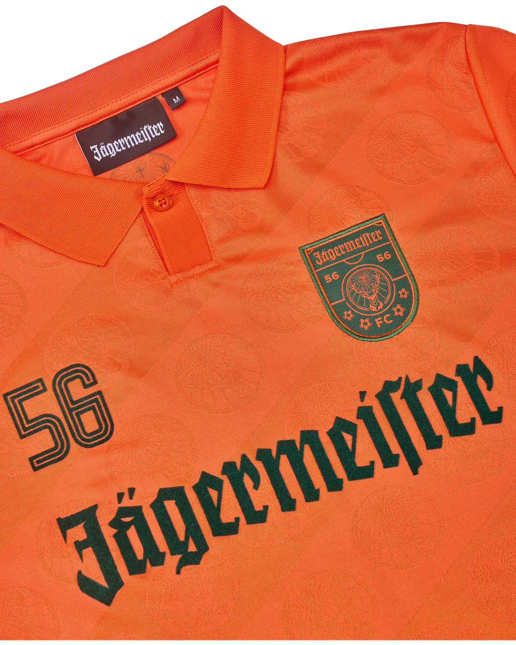 Maillot orange avec la marque Jägermeister.
