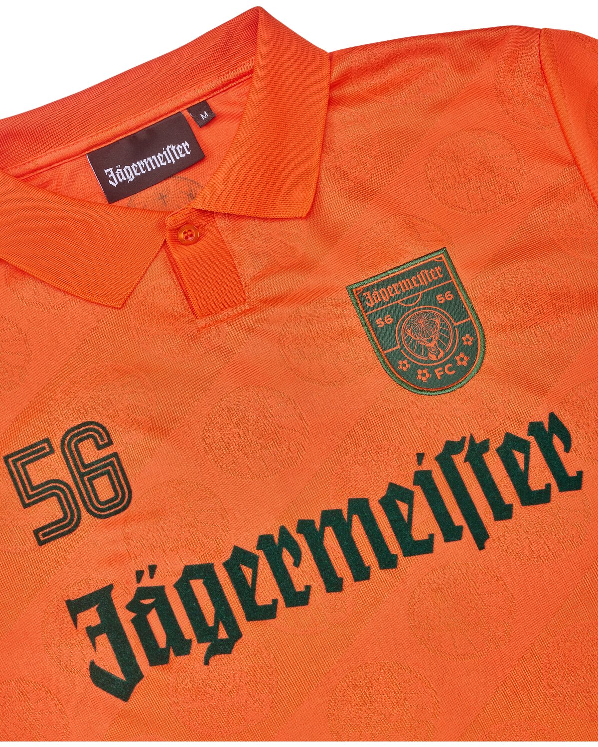 Maillot orange avec la marque Jägermeister.