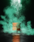 Mug with 'Jagermeister' and 'Pantone Culture Orange' text, surrounded by colorful smoke on a dark background