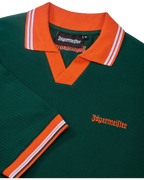 Polo Jägermeister vert avec col et liserés orange, avec branding Jägermeister.