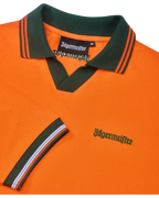 Polo Jägermeister orange avec col vert et liserés orange, avec branding Jägermeister vert.
