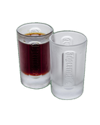 Deux verres à shot Jägermeister blancs contenant un liquide foncé