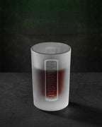 Verre à shot Jägermeister blanc avec le logo Jägermeister en relief
et du liquide à l’intérieur
