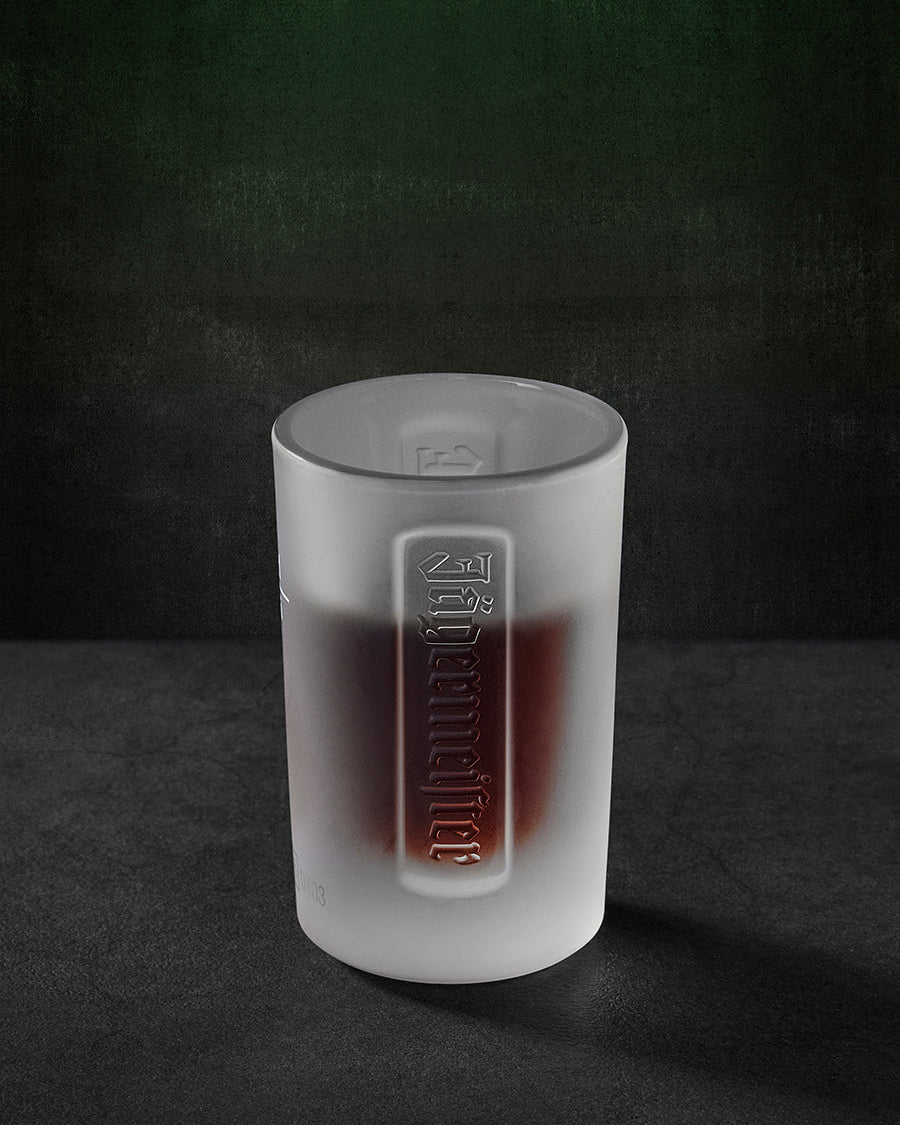 Verre à shot Jägermeister blanc avec le logo Jägermeister en relief
et du liquide à l’intérieur