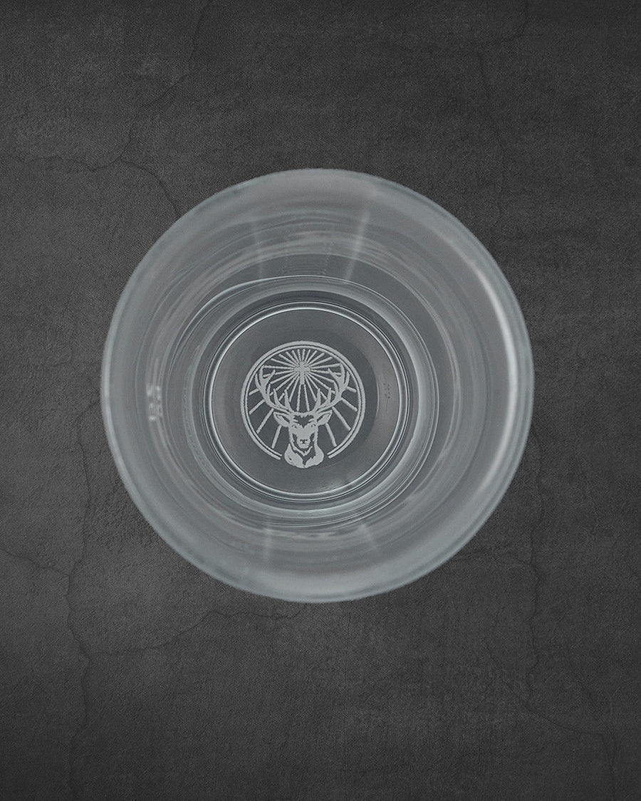 Verre à shot Jägermeister blanc vu de dessus avec le logo du cerf sur le fond
